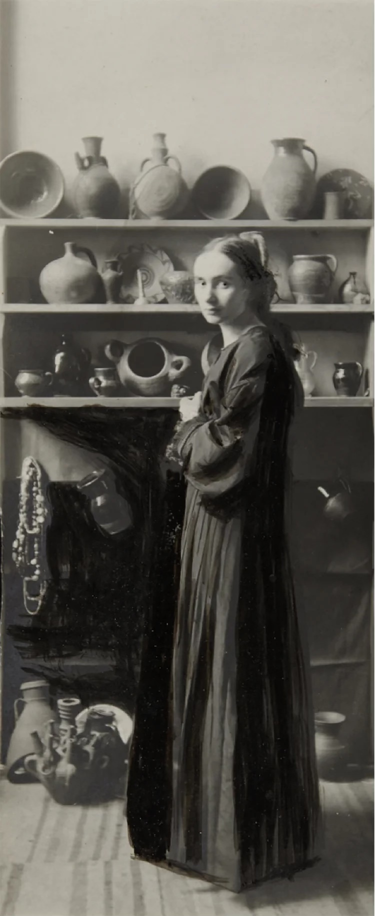 Woman early 1900s standing in an artist studio.