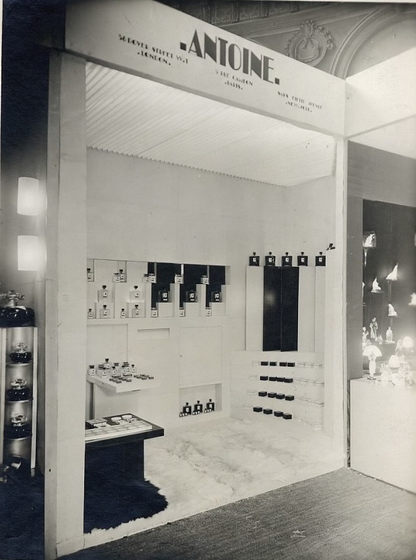 White stand for cosmetics and hair styling at an industrial or commercial fair. White with the text Antoine.