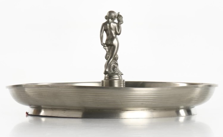 Metalwork plate by Sylvia Stave with naked woman seen from behind in the center.