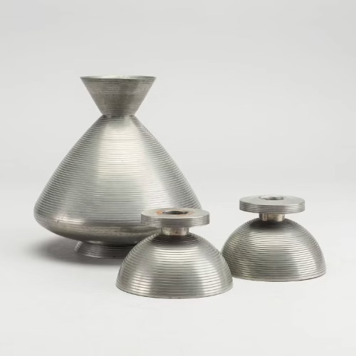 Metalwork vase and two candlesticks by Sylvia Stave.