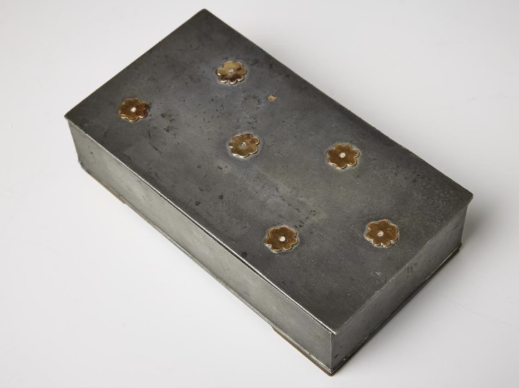 Metalwork box with brass flowers on top of the lid by Sylvia Stave.
