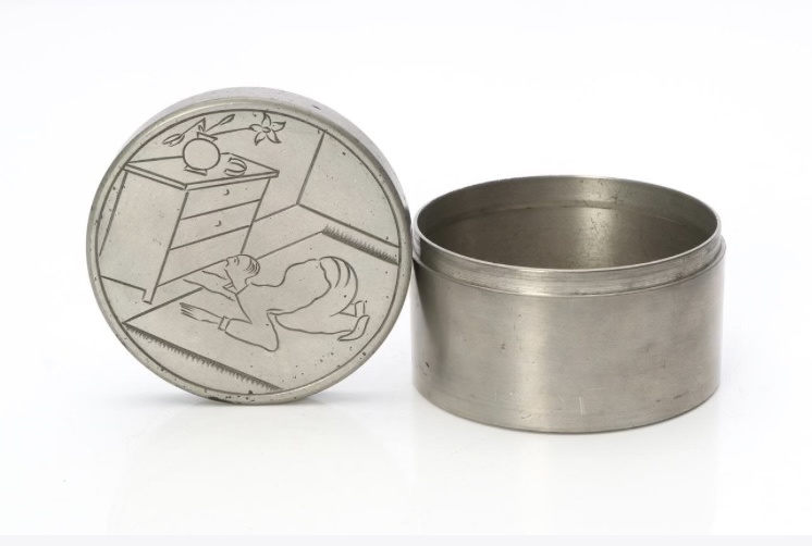 Metalwork tin jar by Sylvia Stave. On the lid image of man looking for cufflinks under chest of drawers.